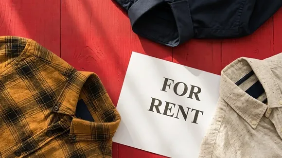 Shirts surround a "FOR RENT" sign on a red wooden surface, suggesting clothing rental or secondhand apparel.