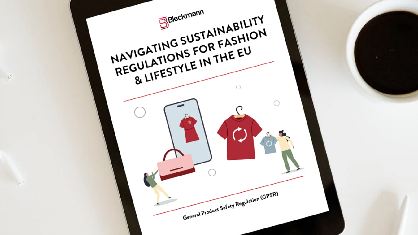 A tablet displaying a document titled "Navigating Sustainability Regulations for Fashion & Lifestyle in the EU" is on a white table next to a cup of coffee.