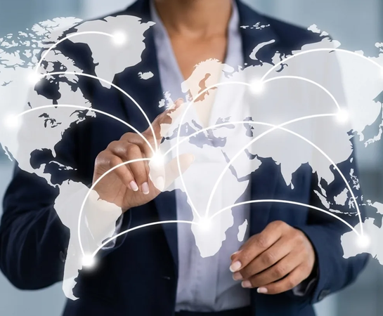 A person in business attire touching a transparent screen displaying a world map with interconnected lines, symbolizing global communication or networking.