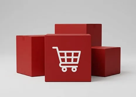 Three red cubes on a light background, with one cube displaying a white shopping cart icon on its front face.