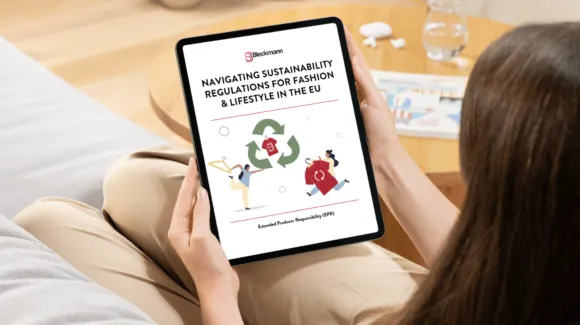 Person holding a tablet displaying a document titled "Navigating Sustainability Regulations for Fashion & Lifestyle in the EU" with illustrations of people and recycling symbols.