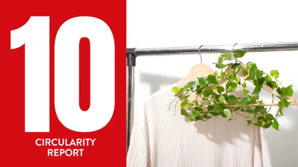 A large white number 10 and the words "Circularity Report" appear on a red background next to a white shirt on a rack with a leafy green vine hanging from a wooden hanger.