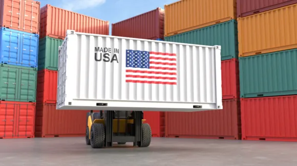 A forklift lifts a white shipping container labeled "Made in USA" with an American flag, surrounded by stacked red, orange, green, and blue containers.