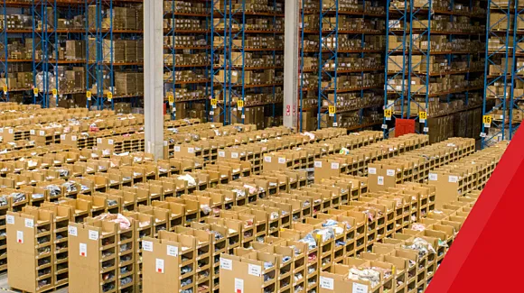 Large warehouse interior with rows of shelves and boxes organized in sections, high racks filled with inventory, and red graphic overlay on the right side.