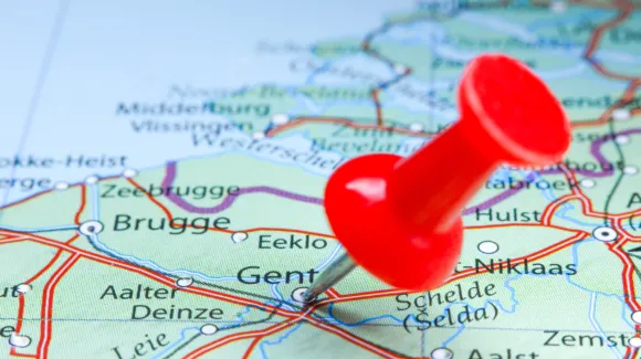 A red pushpin marks the city of Gent on a detailed map of Belgium, showing surrounding cities, roads, and rivers.