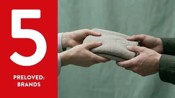 Two people exchange a folded knit sweater in front of a green background. A large number 5 and the words "Preloved: Brands" appear on a red panel on the left.