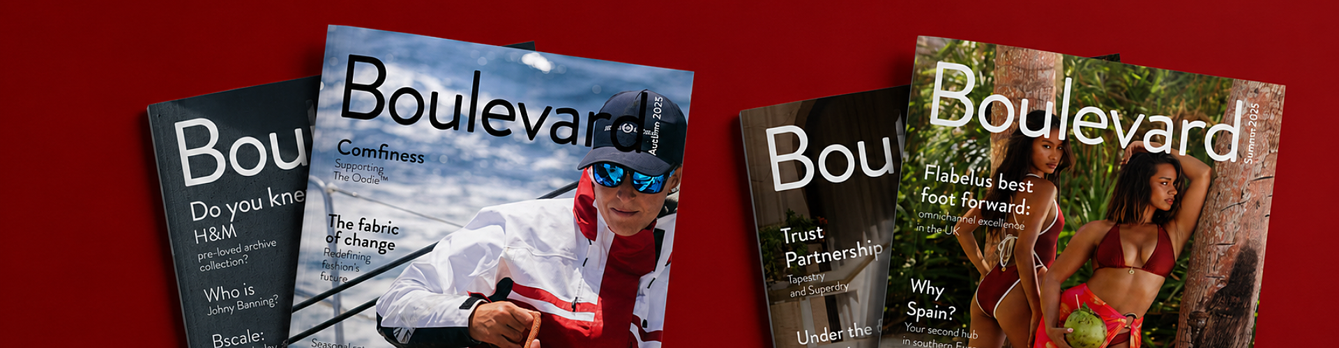 Four issues of Boulevard magazine are laid out on a red surface, featuring covers with fashion, travel, and lifestyle themes, including a person in outdoor wear and two women posing by a tree.