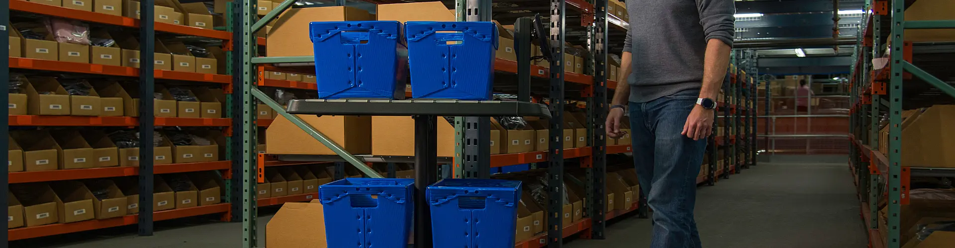 Man walking behind robot in warehouse