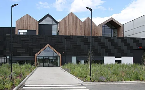 A modern building with contrasting black and white walls and a prominent sign.